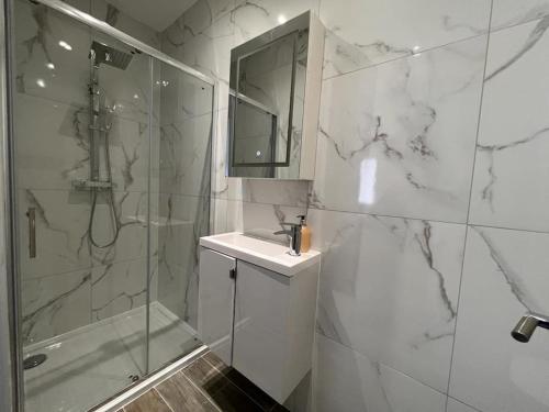 a bathroom with a shower and a sink and a mirror at Star London Finchley Road 1-Bed Hideaway in London