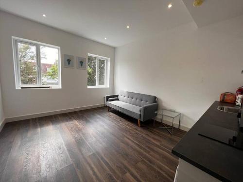 an empty living room with a couch in the corner at Star London Finchley Road 1-Bed Hideaway in London