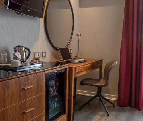 a room with a desk with a mirror and a chair at The Queens Gate Hotel in London