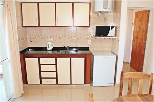 a small kitchen with a sink and a microwave at Urunday Apart Hotel in Posadas