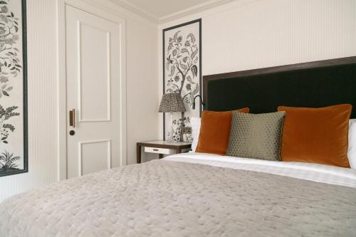 a bedroom with a large white bed with orange pillows at The City of London Club in London