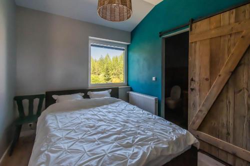 a bedroom with a large bed and a window at Siedlisko Pili Pili in Sorkwity