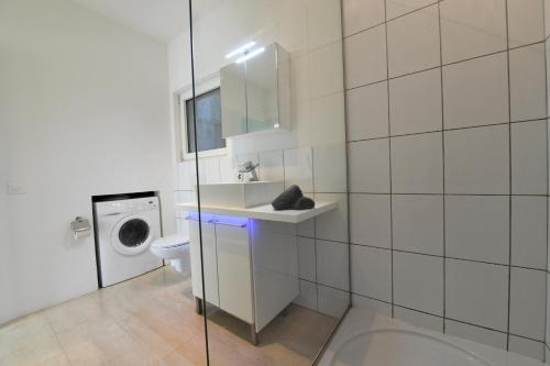 a bathroom with a toilet and a sink and a washing machine at The Minimal House & SPA in Caslano
