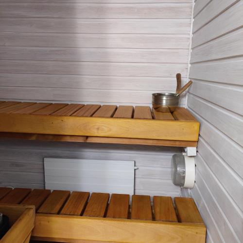 a sauna with wooden steps and a metal pot at Sataman helmi in Savonlinna