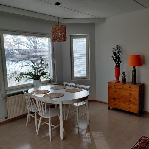 uma sala de jantar com uma mesa branca e cadeiras em Sataman helmi em Savonlinna