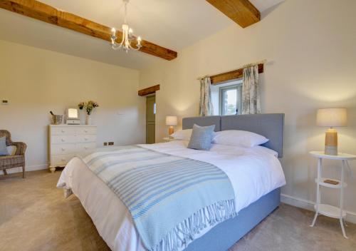 a bedroom with a large bed and a window at Barton Barn in Bishops Nympton