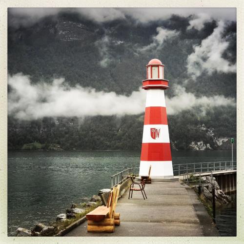 a red and white lighthouse on the end of a dock at Chalet im Gus - Flumserberge & Walensee in Oberterzen
