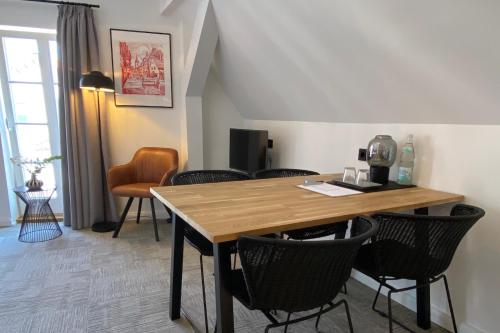 - une salle à manger avec une table et des chaises en bois dans l'établissement Wertschätzer Hotel - Krumme Str, à Detmold