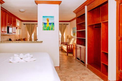 a bedroom with a white bed and wooden cabinets at Mayan Princess Hotel in San Pedro