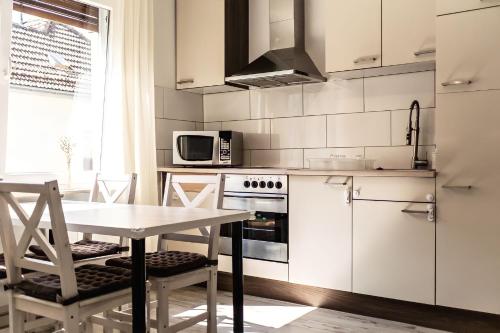 a kitchen with white appliances and a table and chairs at in Dattenberg in Dattenberg