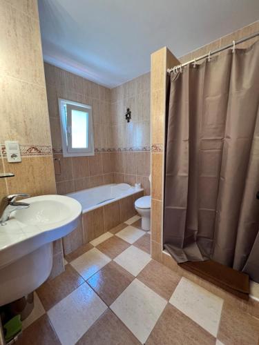 een badkamer met een bad, een toilet en een wastafel bij Casa Delfin: Luxurious villa with heated pool & mountain views in Cómpeta