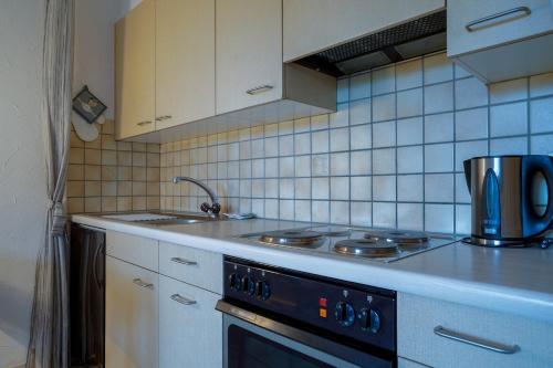 a kitchen with a stove and a sink at Studio by the Pool in Caslano