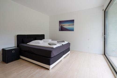 a bedroom with a bed in a white room at The Glass House & SPA in Caslano