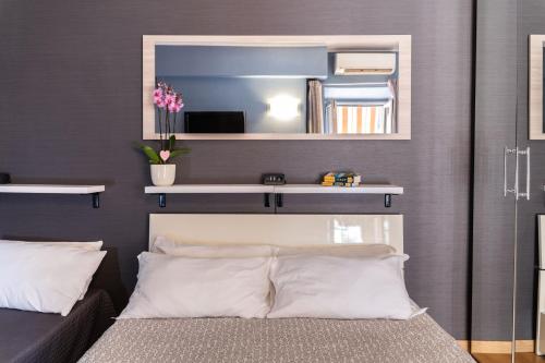 a bedroom with a mirror above a bed at Dulcis In Colosseo Apartments in Rome