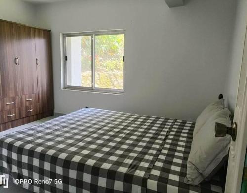 a bedroom with a bed with a checkered blanket on it at Romytt White House in Virac