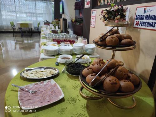 a table topped with plates of food and pastries at Hotel De Las Flores in Ambato