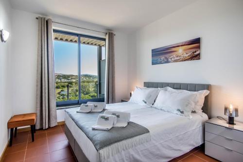a bedroom with a large bed and a large window at Swiss Green Appartement Cosy et Spacieux in Quarteira