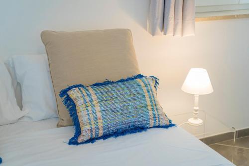 a bed with a pillow and a lamp on it at MARIMAR - Apartments OTRANTO in Otranto
