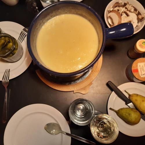a pot of soup on a table with plates and spoons at Chalet im Gus - Flumserberge & Walensee in Oberterzen