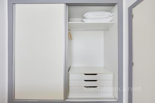 a closet with white cabinets and a mirror at Luxurious, Newly-Renovated Large 2-Bedroom Condo by the Beach in Benidorm