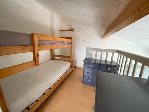 a bedroom with two bunk beds and a desk at maison vue sur mer dans les dunes avec acces direct aux plages in Bretignolles-sur-Mer