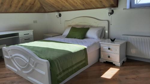 una camera con un letto con una coperta verde e bianca di Апартаменти - Історія з вікна a Kam"janec'-Podil's'kyj