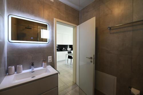 uma casa de banho com um lavatório e um espelho em Ascona for Two em Ascona