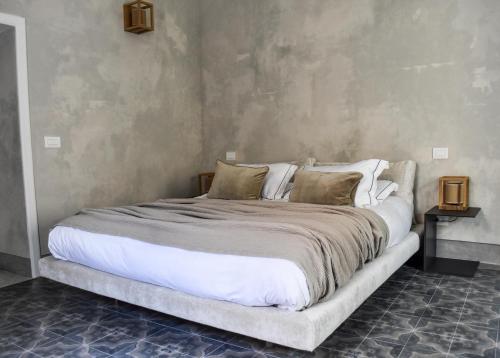 a bedroom with a large bed with white sheets and pillows at Casa Esther in Siracusa