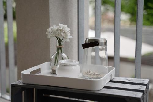 a white tray with a vase and flowers on a table at Haus No 6 in Lahr