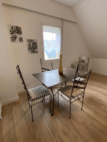 comedor con mesa, sillas y ventana en Studio lumineux de 35m2 au cœur de Solesmes en Solesmes