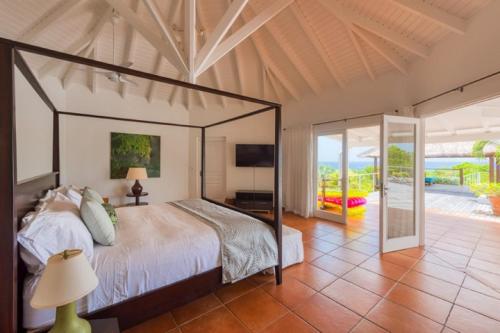- une chambre avec un grand lit et une terrasse dans l'établissement Holiday Villa 12, à Rambaud