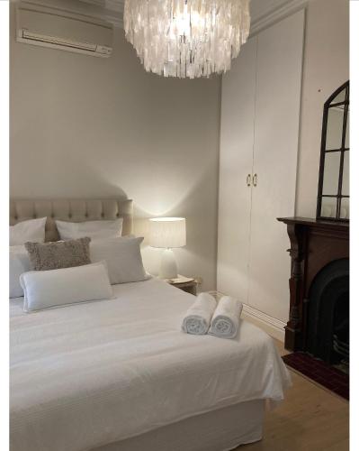 Un dormitorio con una cama blanca con toallas. en The Richmond Cottage en Melbourne