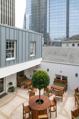 a patio with benches and a tree on a building at The City of London Club in London