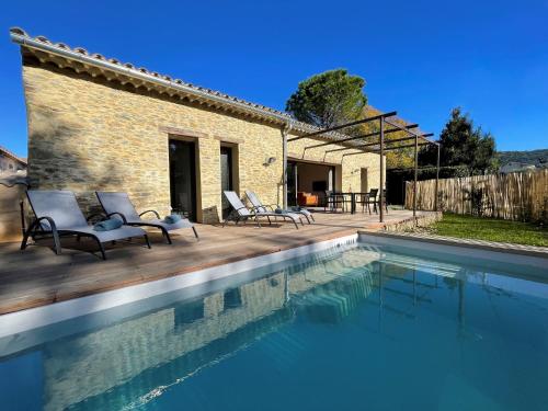 a villa with a swimming pool in front of a house at Le cèdre bleu in Sablet