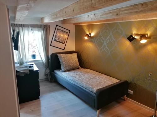 ein kleines Schlafzimmer mit einem Bett in einem Zimmer in der Unterkunft Zum Pfarrberg in Meerane