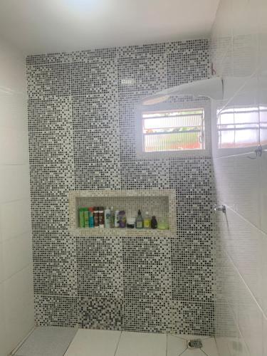 uma casa de banho com um chuveiro com azulejos pretos e brancos em Casa chácara para alugar no período do festival de Parintins em Parintins