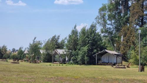 a tent and picnic tables in a field at Moraycamp in San Andrés de Giles