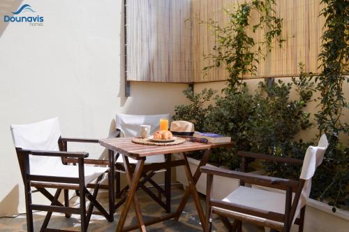 une table en bois avec deux chaises et une bougie dessus dans l'établissement Dounavis Homes: The Hidden Olive, à Ermoúpoli