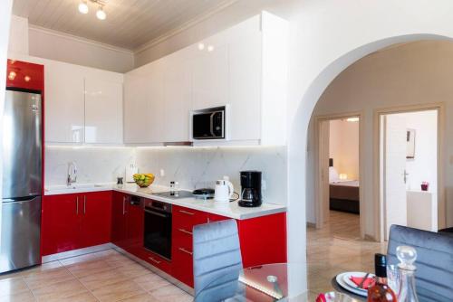 a kitchen with red cabinets and a silver refrigerator at Antiopi's Vacation House in Argyrádes