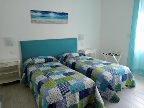 1 dormitorio con 2 camas individuales y edredón en Casa Nova b&b en Alghero