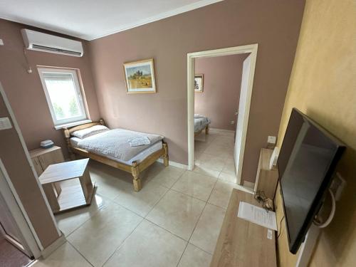 a room with a bed and a television in it at Vila Boska Palic in Palić