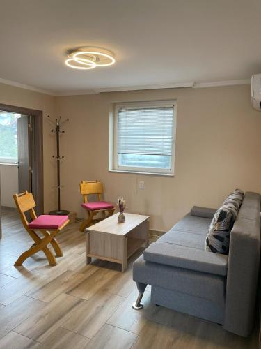 a living room with a couch and a table and chairs at Vila Boska Palic in Palić