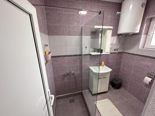 a purple bathroom with a shower and a sink at Vila Boska Palic in Palić