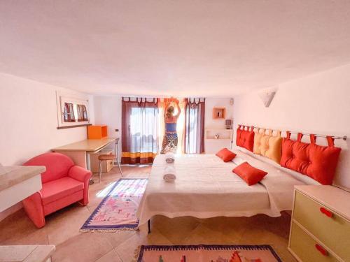 a bedroom with a large bed and a red couch at Hibryd: in centro, a due passi dal mare in Oristano