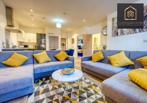 a living room with blue couches and a table at Two bedroom - Central Peterborough - New Year Discount in Peterborough