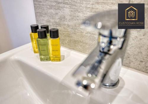two bottles of oils sitting on a bathroom sink at Two bedroom - Central Peterborough - New Year Discount in Peterborough