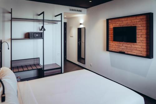 a room with a bed and a tv on a wall at ONOMO Hotel Casablanca Sidi Maarouf in Casablanca