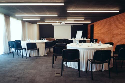 a room with white tables and chairs and a brick wall at ONOMO Hotel Casablanca Sidi Maarouf in Casablanca