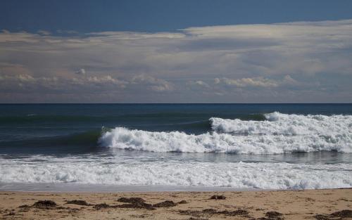 two waves in the ocean on a beach at La Villetta in Pula