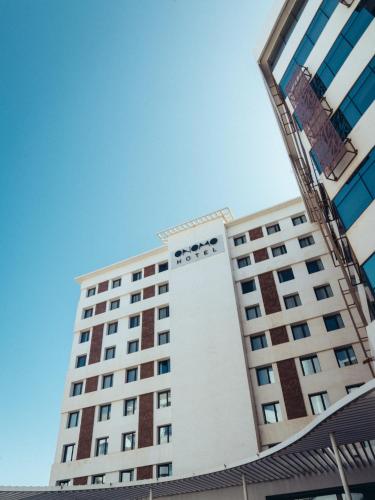 a tall white building with a blue sky in the background at ONOMO Hotel Casablanca Sidi Maarouf in Casablanca